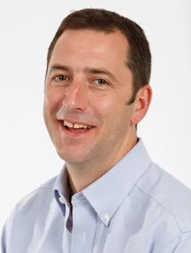 Formal portrait of Associate Professor Gareth Howell against a white background.